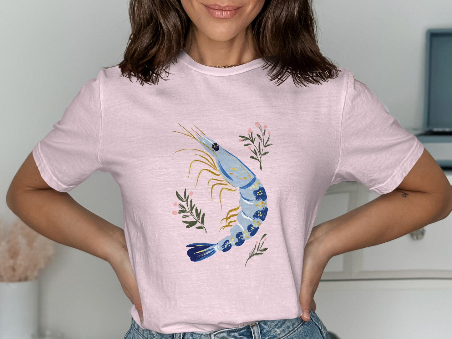Pink t-shirt with a blue and white shrimp illustration and floral accents.
