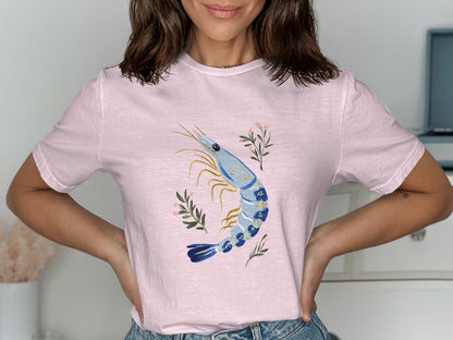 Pink t-shirt with a blue and white shrimp illustration and floral accents.
