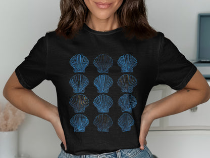 Black t-shirt with a repeating pattern of blue and gold seashell graphics.