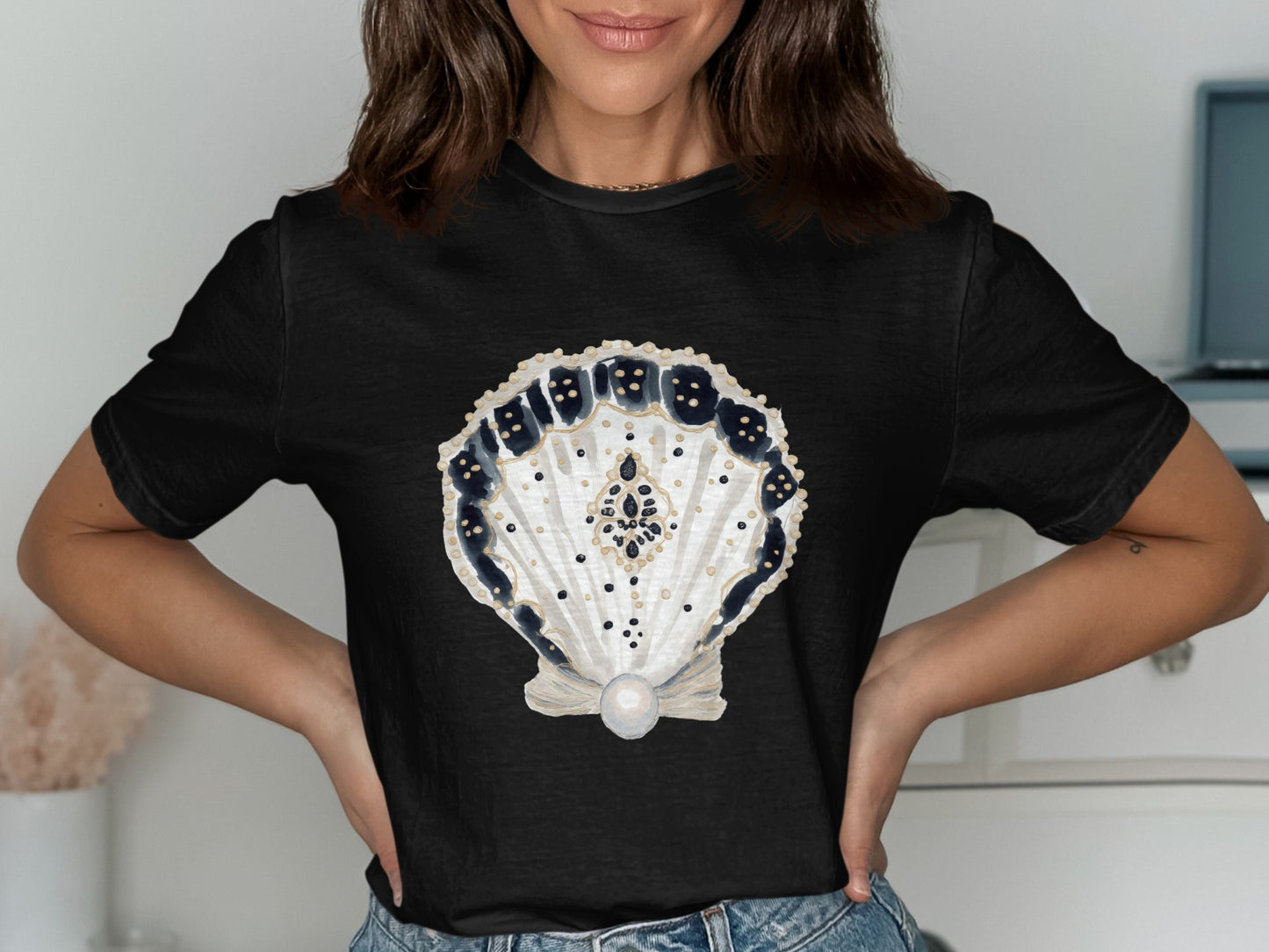 Black t-shirt with a decorative seashell graphic.
