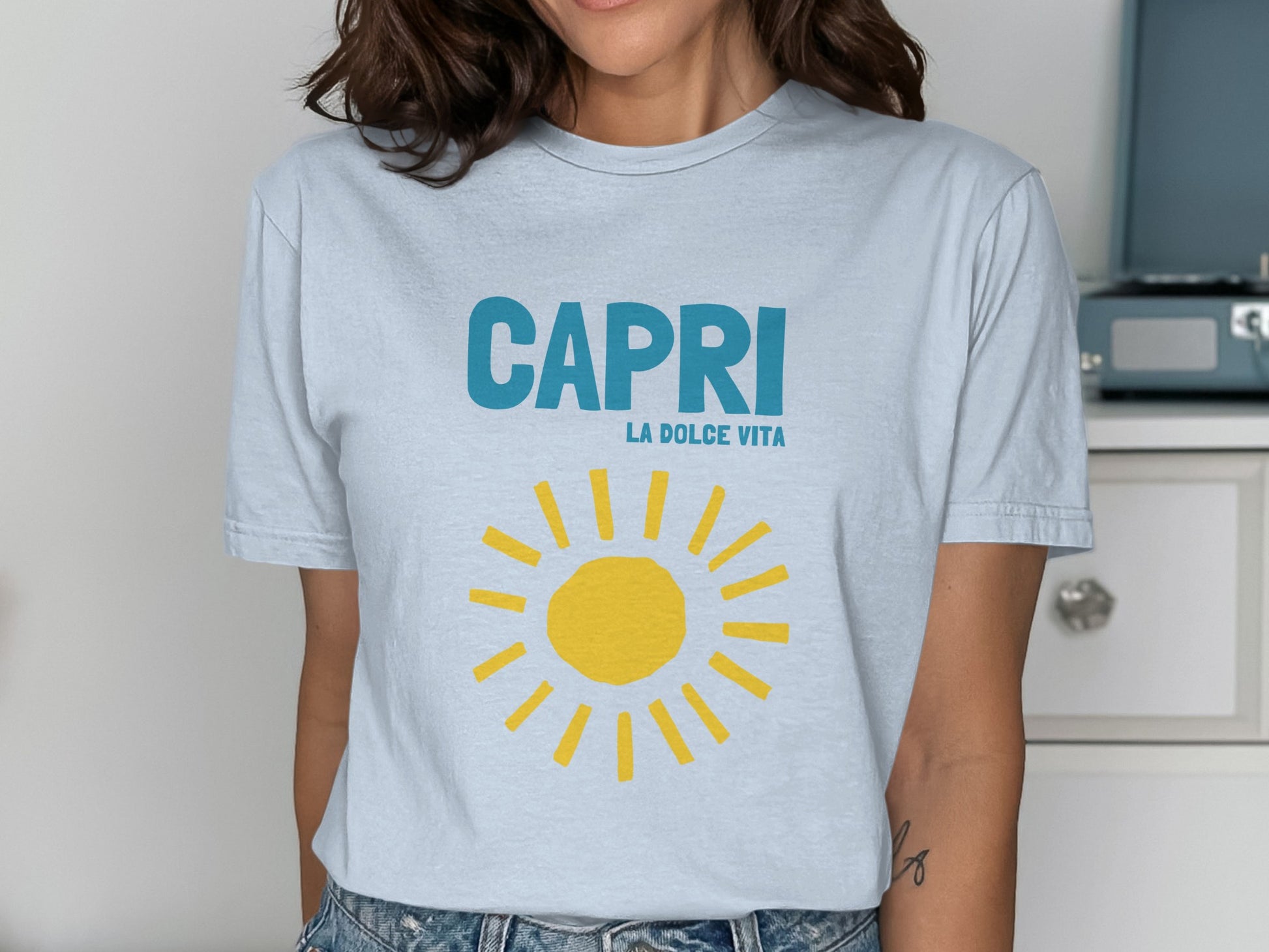 Light blue t-shirt with "CAPRI LA DOLCE VITA" and a yellow sun graphic.