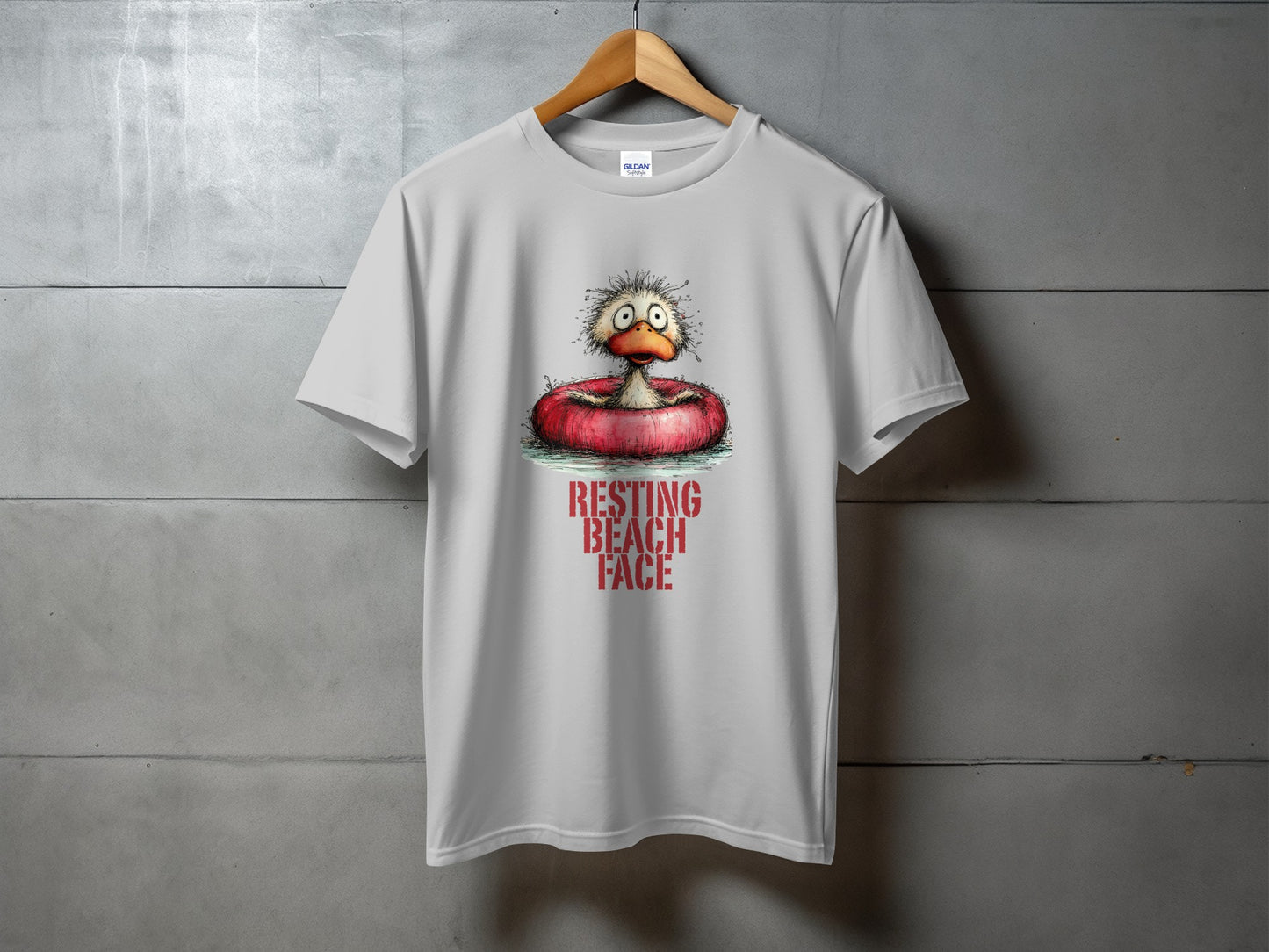 White t-shirt with graphic of cartoon duck in inflatable ring with "RESTING BEACH FACE" text.