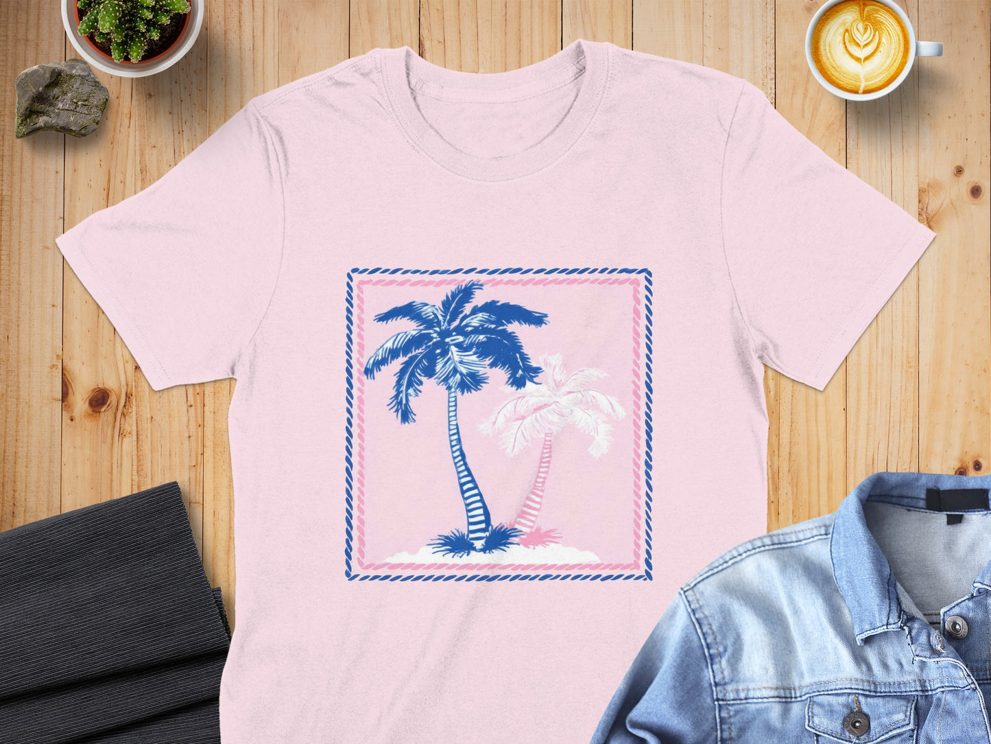 Pink t-shirt with blue and white palm trees in a decorative frame.