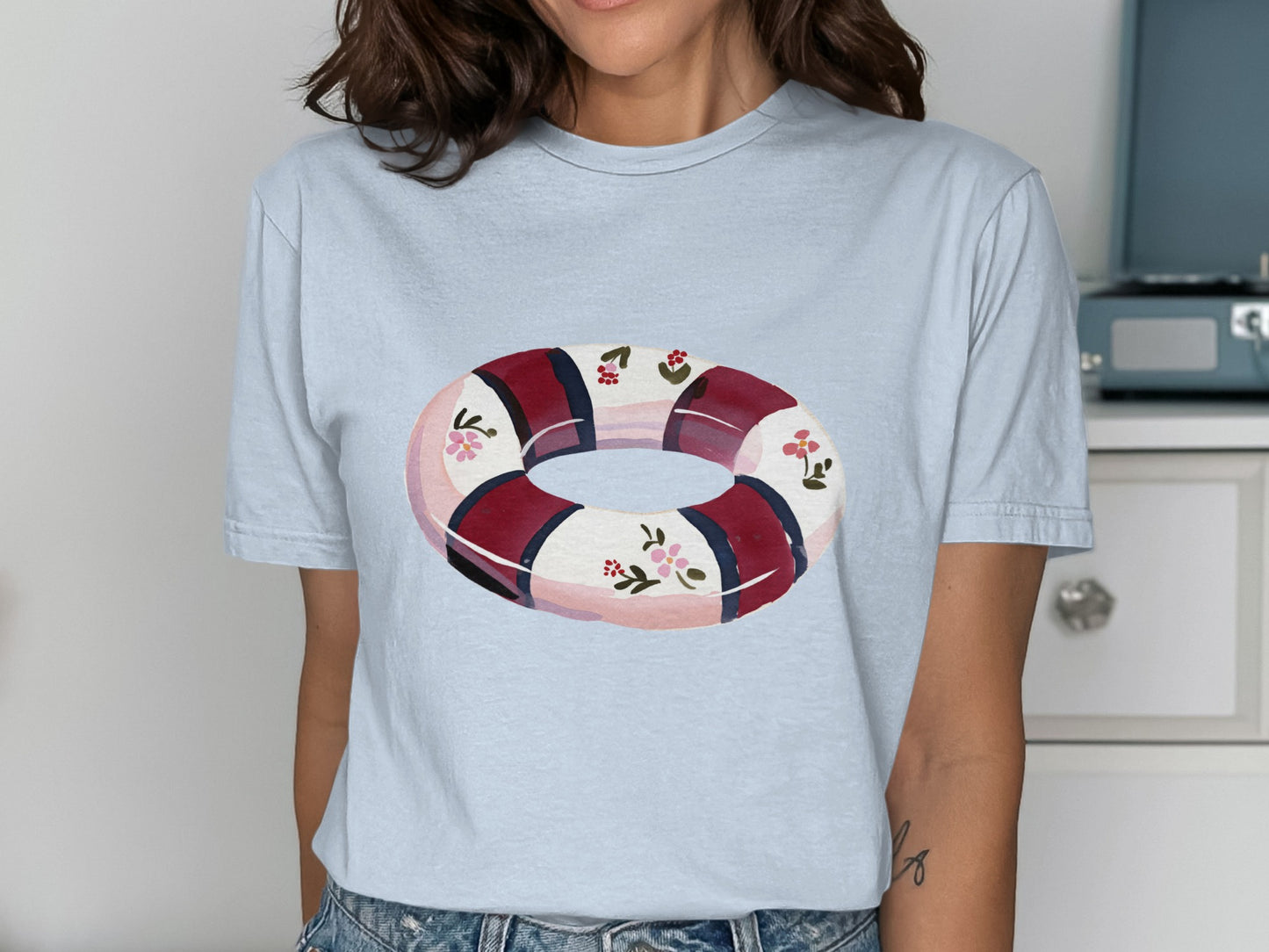 Light blue t-shirt featuring a float with floral and striped pattern.