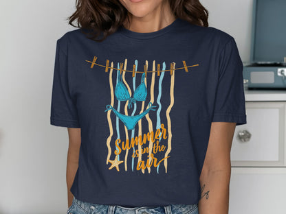 Blue bikini and starfish hanging on clothesline with "Summer is in the air" text.