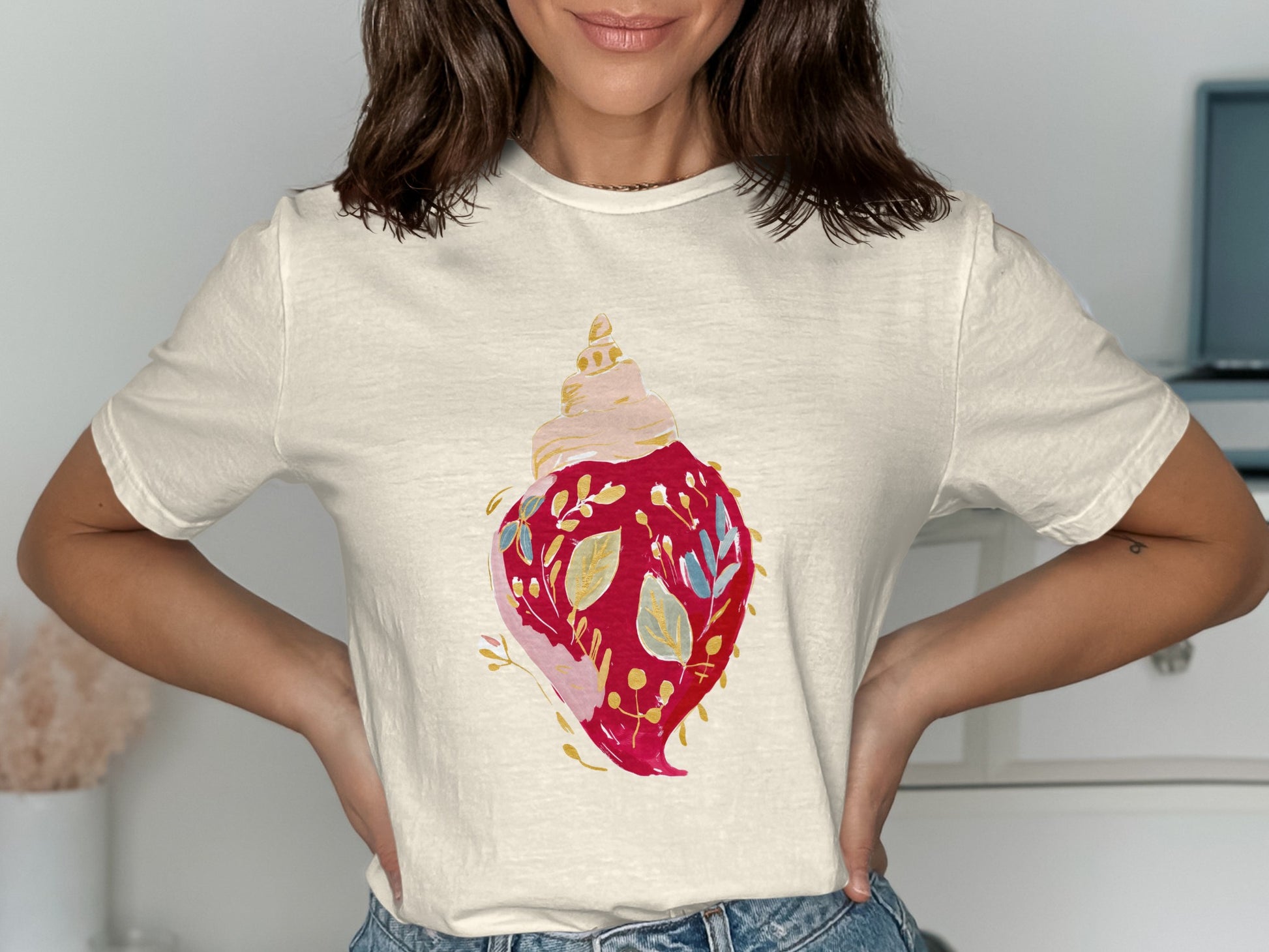 Cream t-shirt with red seashell graphic and blue floral accents.