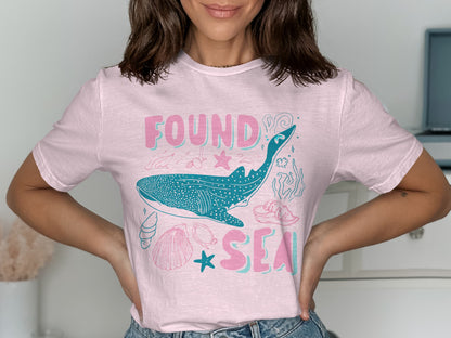 Pink t-shirt with a whale shark and "Found Sea" text.