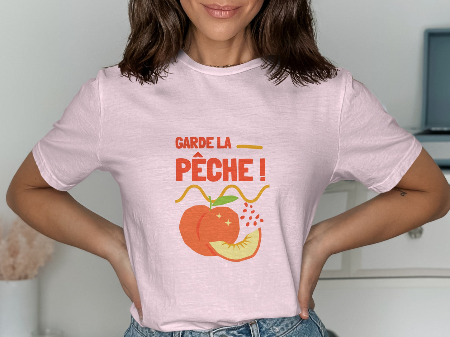 Pink t-shirt with "Garde la pêche!" text and a peach graphic.