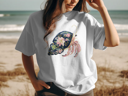White t-shirt featuring a pink hermit crab and floral shell illustration.