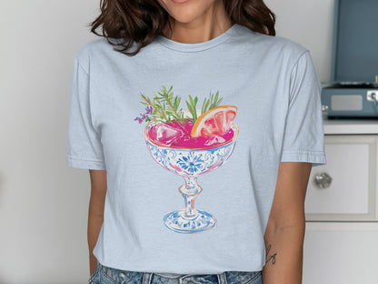 T-shirt featuring a colorful illustration of a cocktail with grapefruit and herbs.
