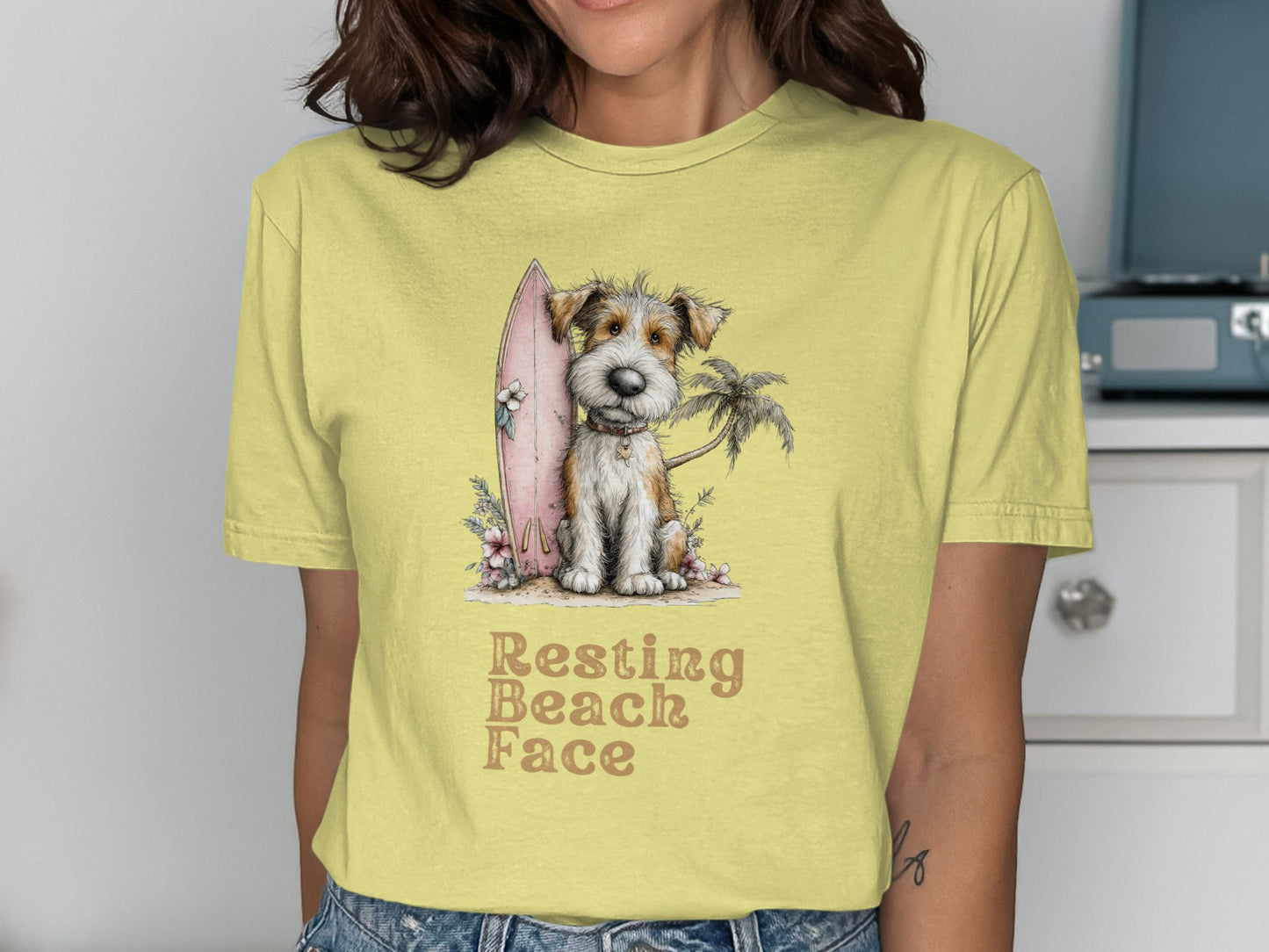 Yellow t-shirt with a scruffy dog, surfboard, and palm tree graphic.