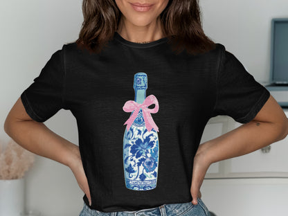 Black t-shirt with blue and white floral champagne bottle and pink bow graphic.
