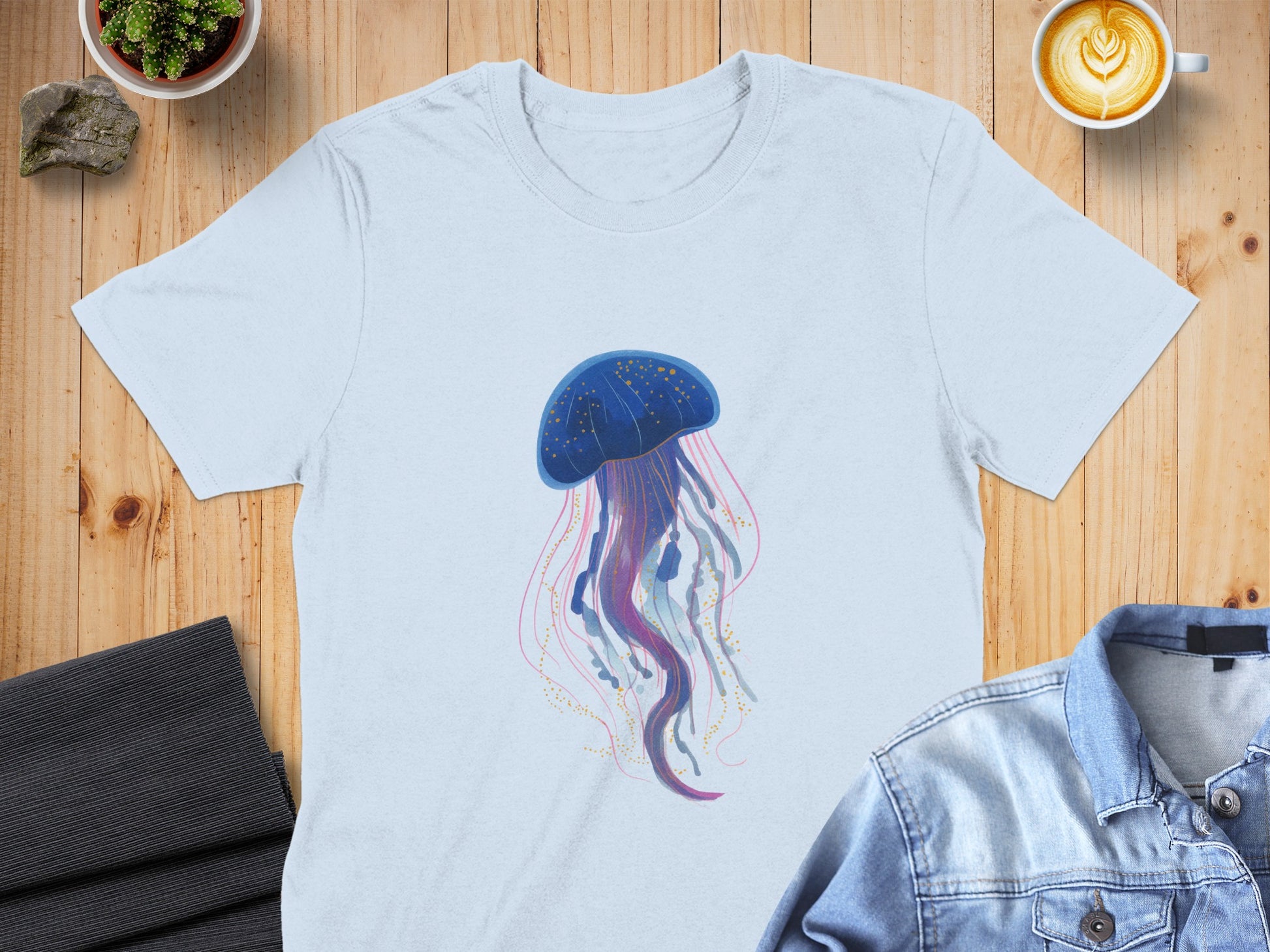 Light blue t-shirt with a blue jellyfish illustration and gold accents.