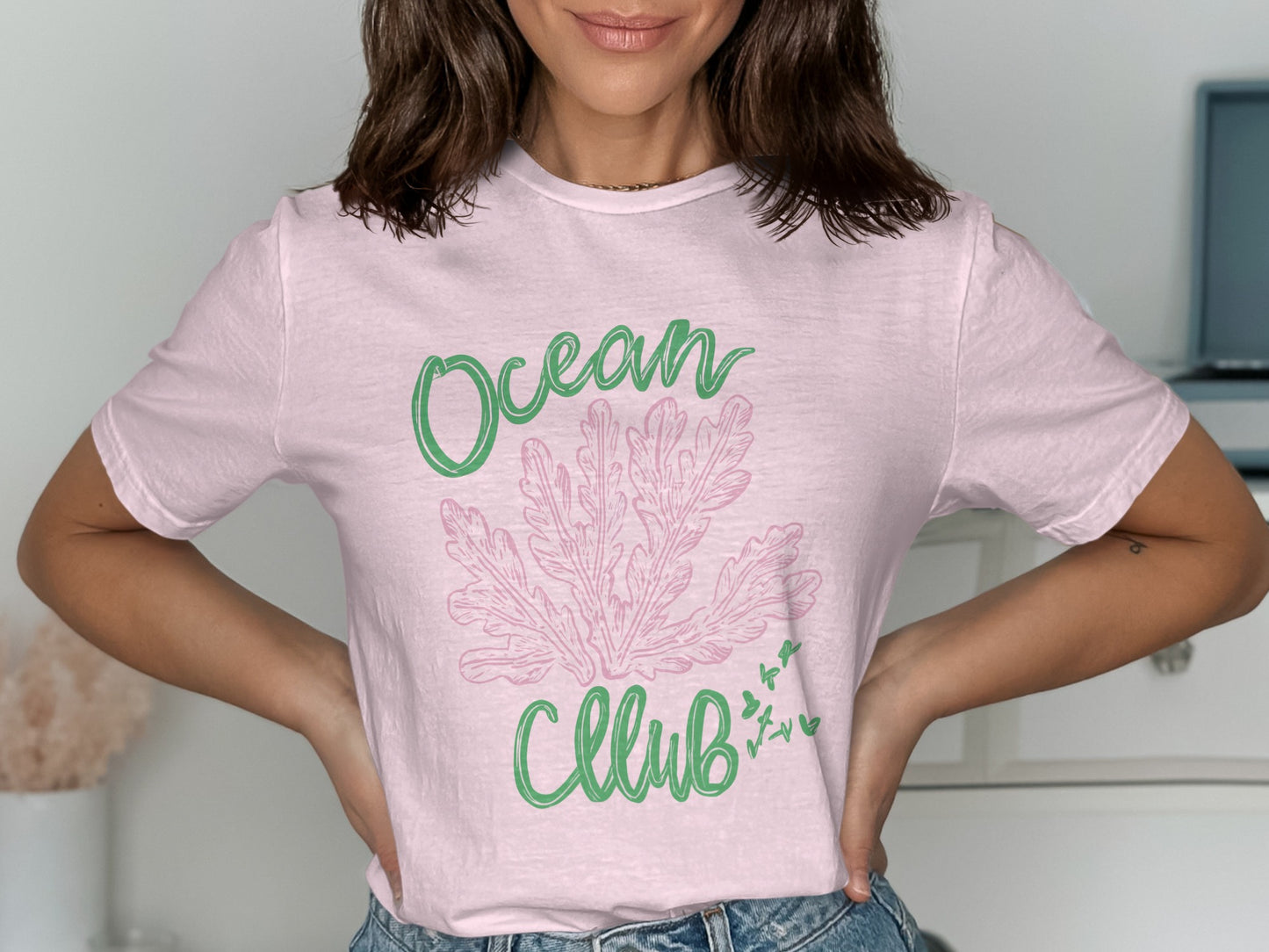 Pink t-shirt with green "Ocean Club" text and coral graphic.