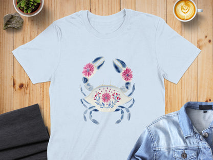 Light blue t-shirt with a watercolor crab design featuring pink flowers and blue floral patterns.