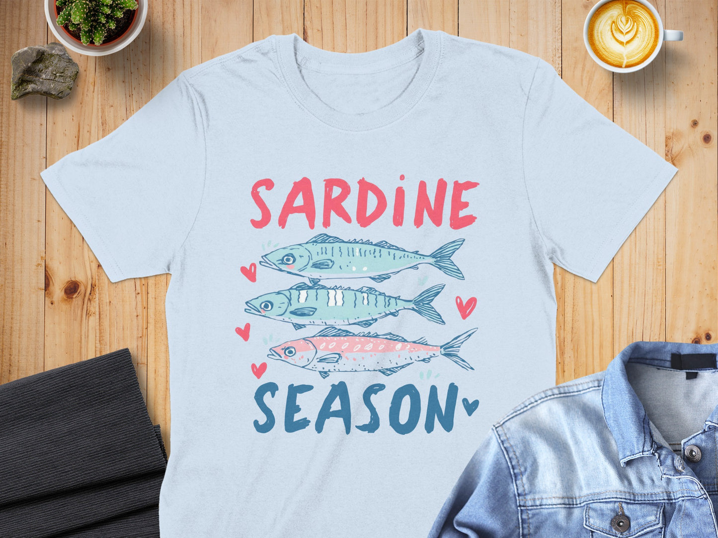 Light blue t-shirt with three sardines and "SARDINE SEASON" text.