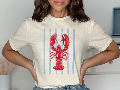 Cream t-shirt with red lobster graphic on blue stripes.