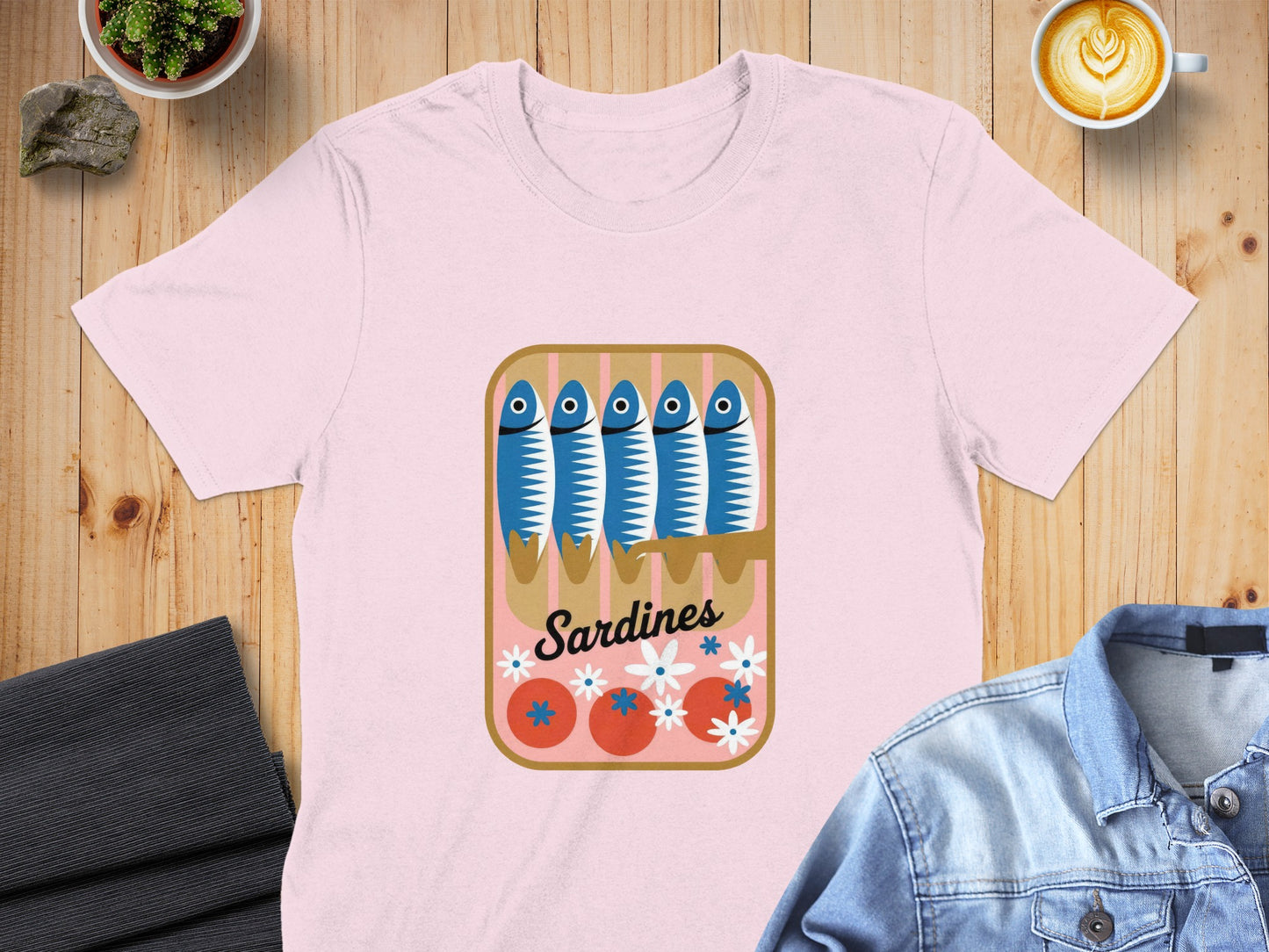 Pink t-shirt with a cartoon sardine can design and "Sardines" text.