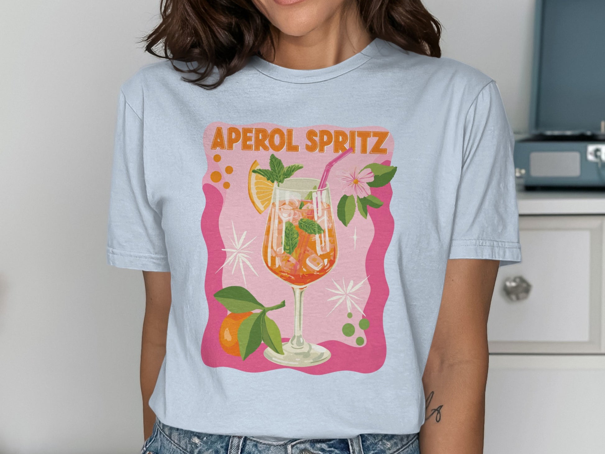 Light blue t-shirt with "Aperol Spritz" text and illustrated cocktail.