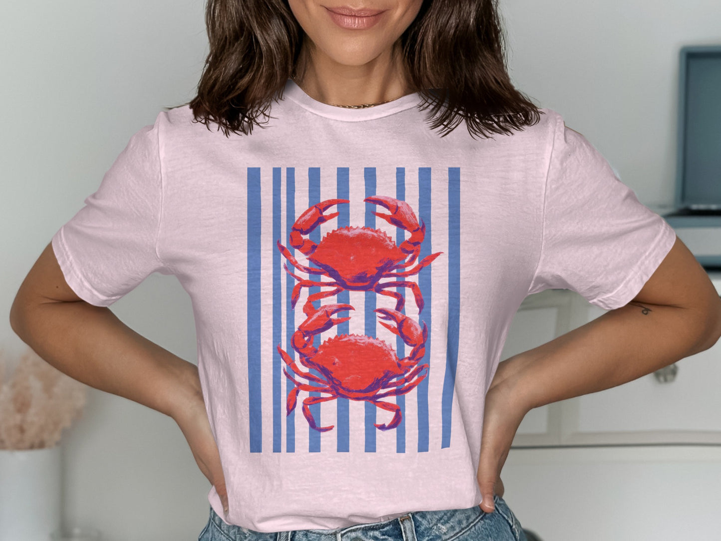 Pink t-shirt with two red crabs on blue and white vertical stripes.