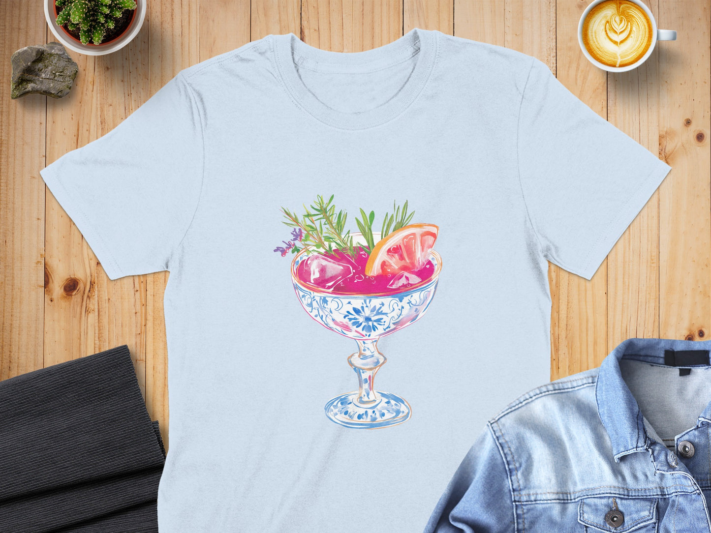 Light blue t-shirt featuring a colorful cocktail illustration with garnish.