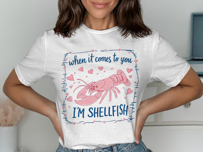 White t-shirt with lobster and "When it comes to you I'm shellfish" text.