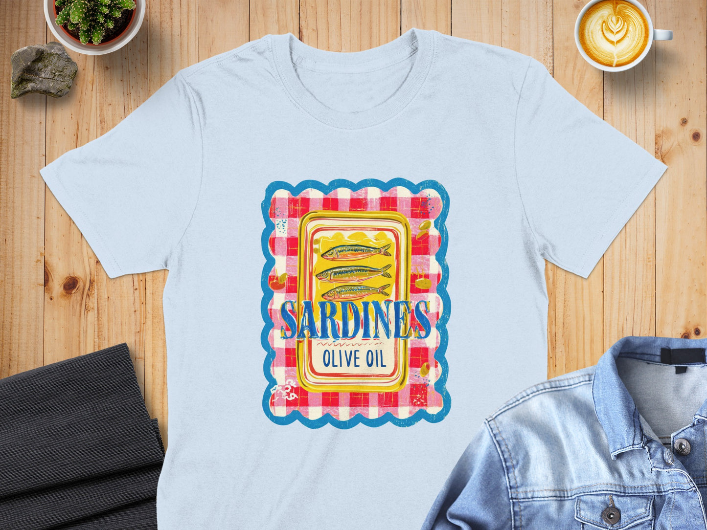 Light blue t-shirt with sardine can illustration in checkered frame.