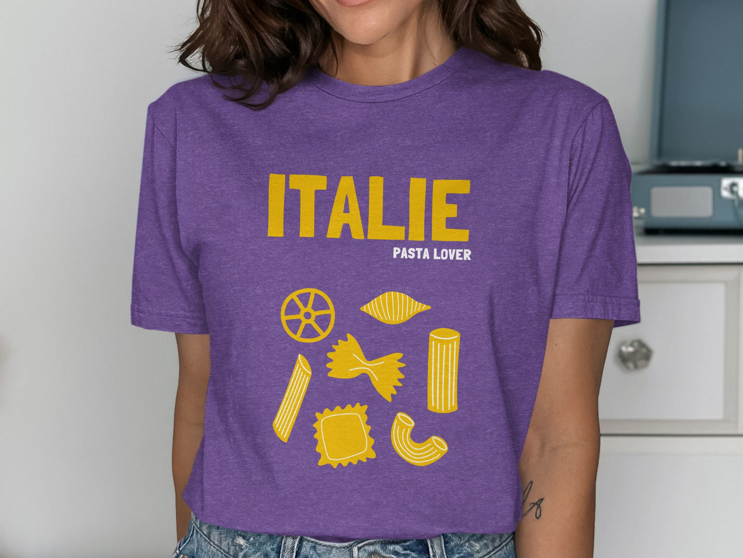 Purple t-shirt with "ITALIE" and "PASTA LOVER" text, featuring pasta shapes.