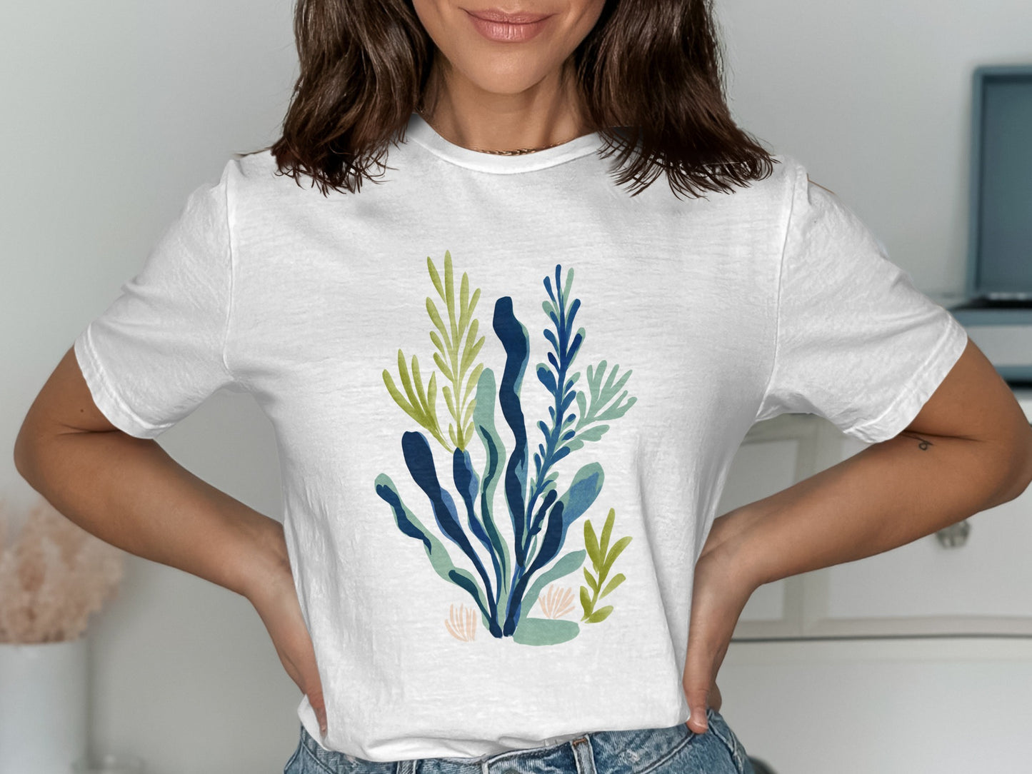 White t-shirt with a blue and green abstract botanical print.