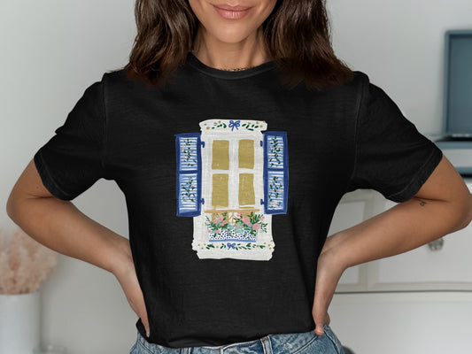Black t-shirt with illustration of a window with blue shutters and flowers.