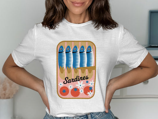 White t-shirt featuring a cartoon sardine can with blue sardines and tomatoes.