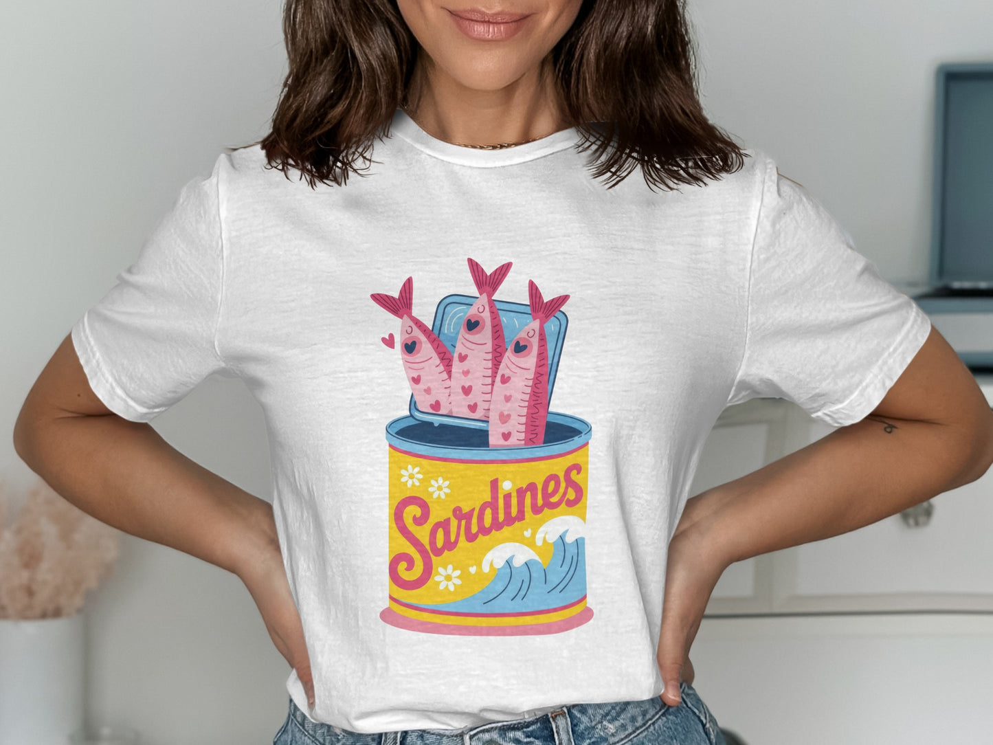 White t-shirt with a graphic of sardines in an open can and waves.