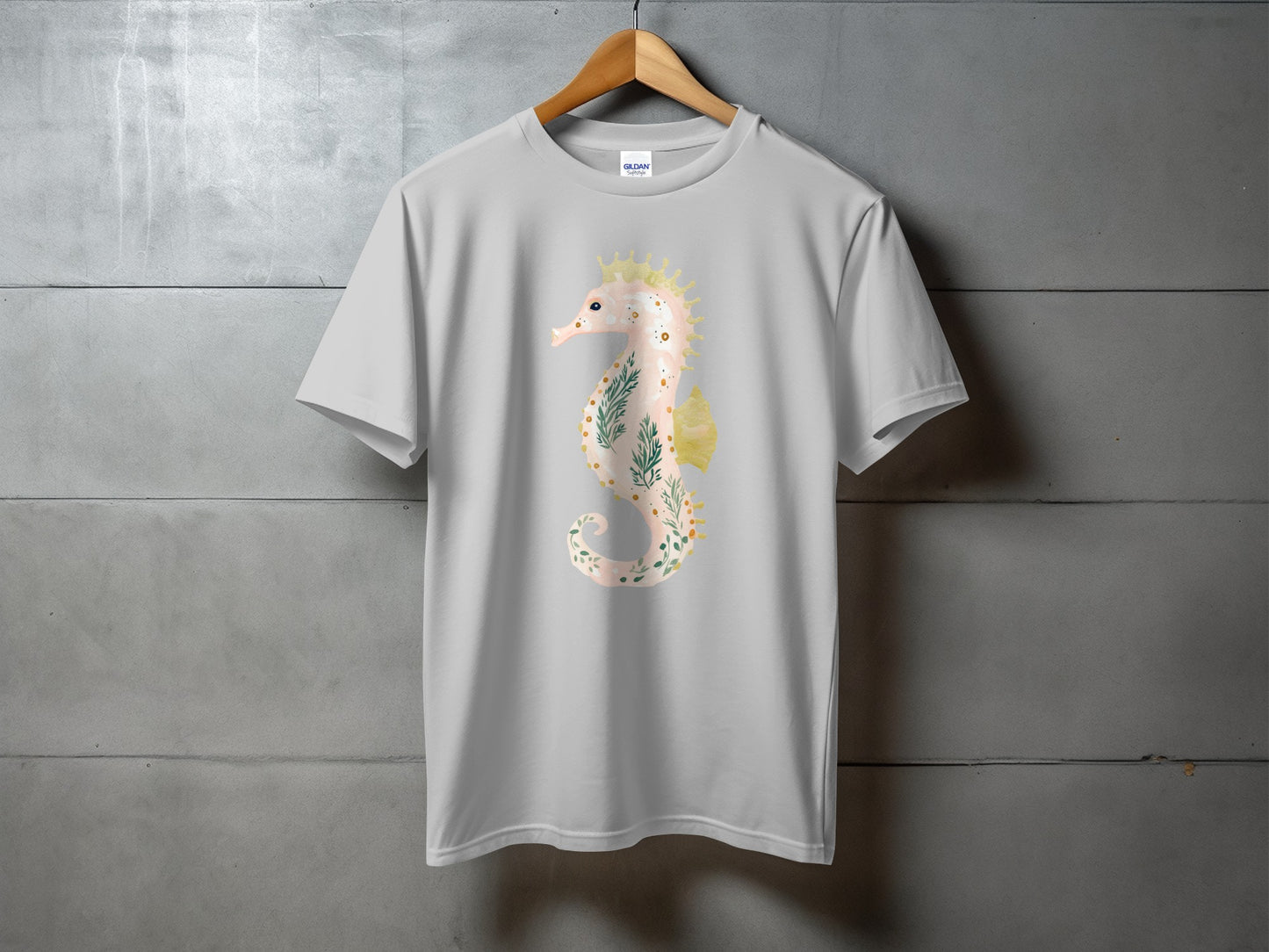 Gray t-shirt with a watercolor seahorse graphic featuring floral and leafy accents.