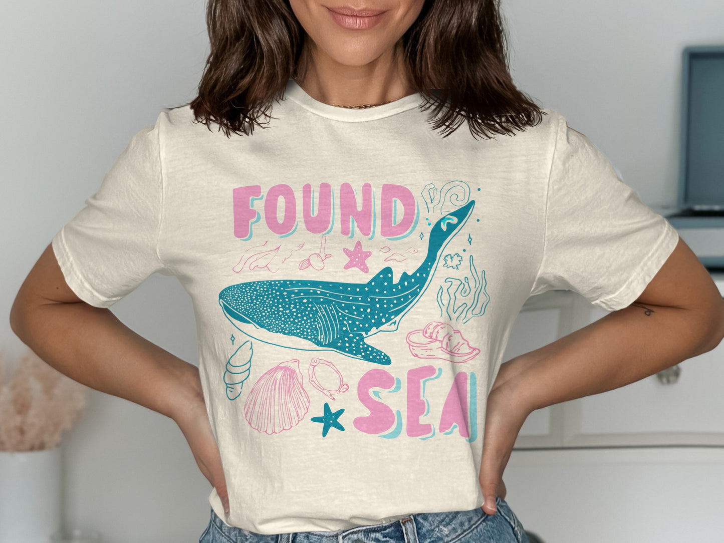 Cream t-shirt with whale shark, shells, starfish, and "Found Sea" text.