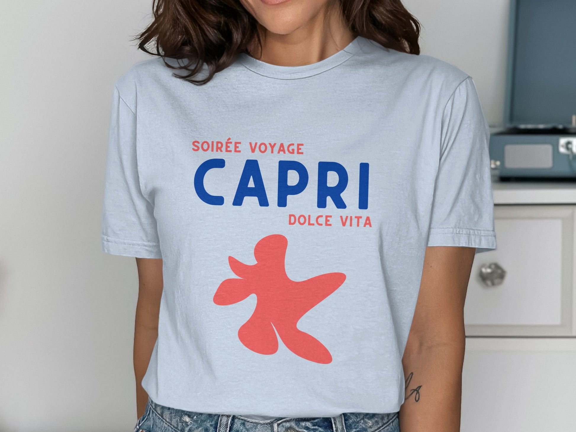 Light blue t-shirt with red abstract figure and "CAPRI DOLCE VITA" text.