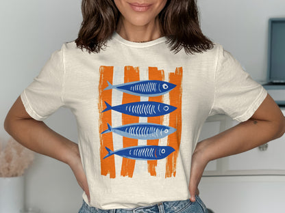 Cream t-shirt with four blue fish on orange stripes.
