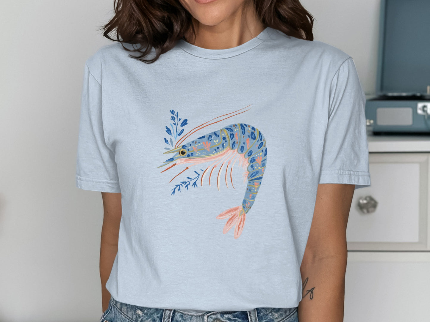 Light blue t-shirt with a colorful shrimp and floral design.