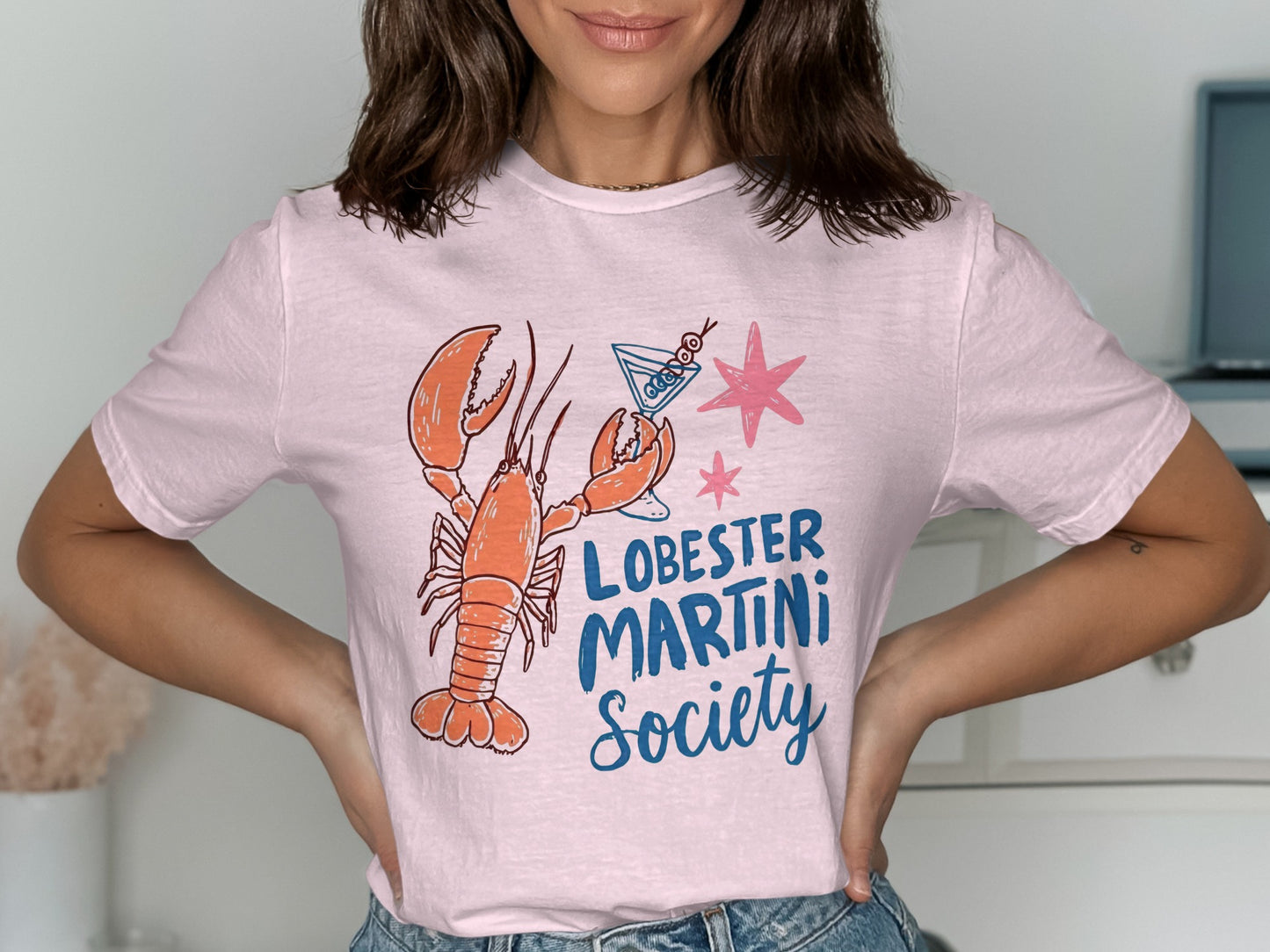 Pink t-shirt with a lobster and martini glass graphic and "Lobster Martini Society" text.