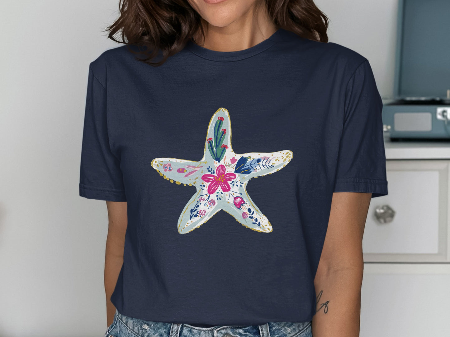 Navy t-shirt with a floral starfish graphic in light blue and pink.