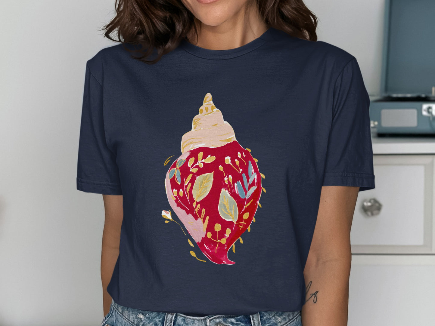 Navy t-shirt with a watercolor seashell and floral design.