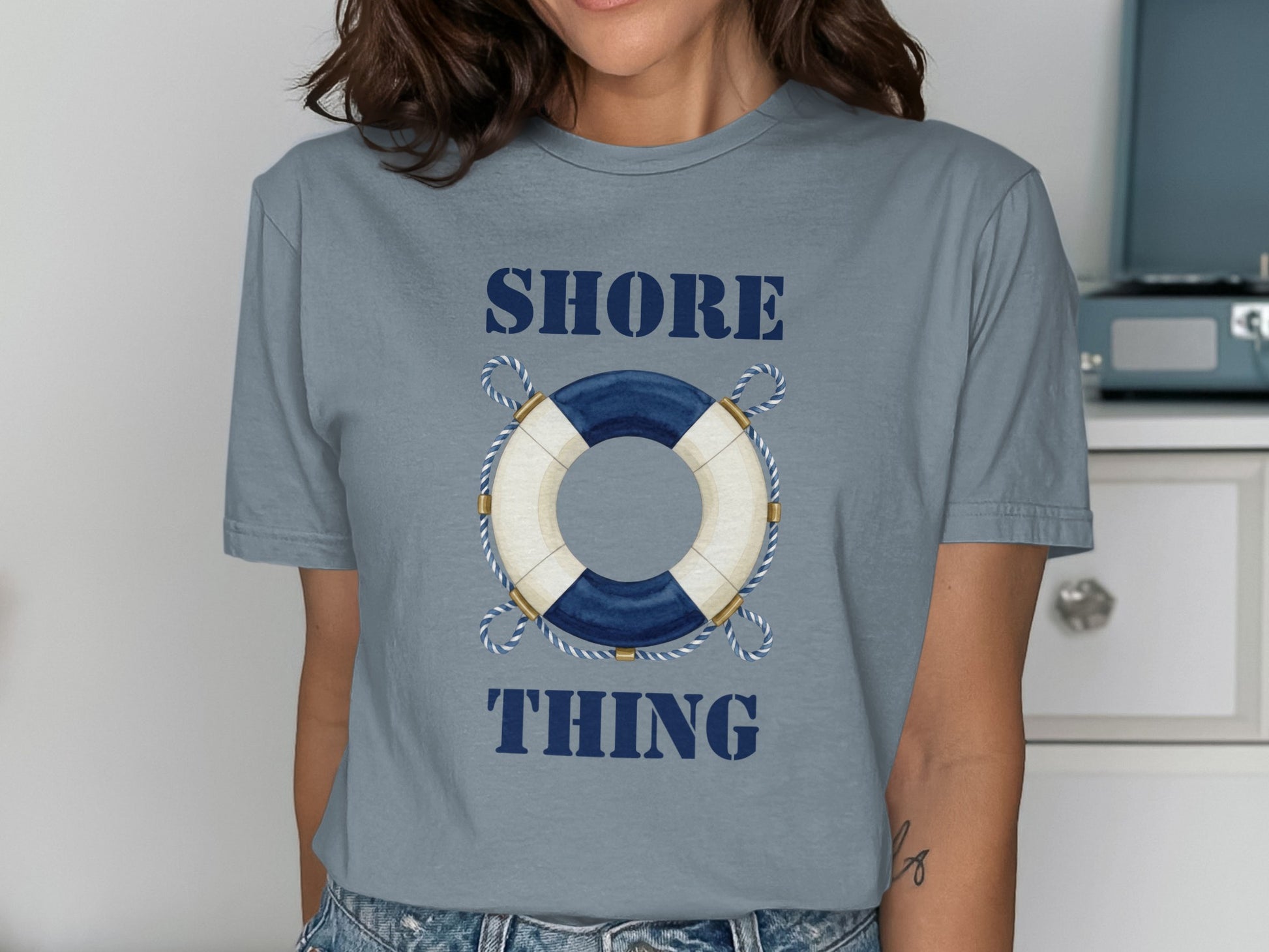 Blue t-shirt with life preserver graphic and "SHORE THING" text.