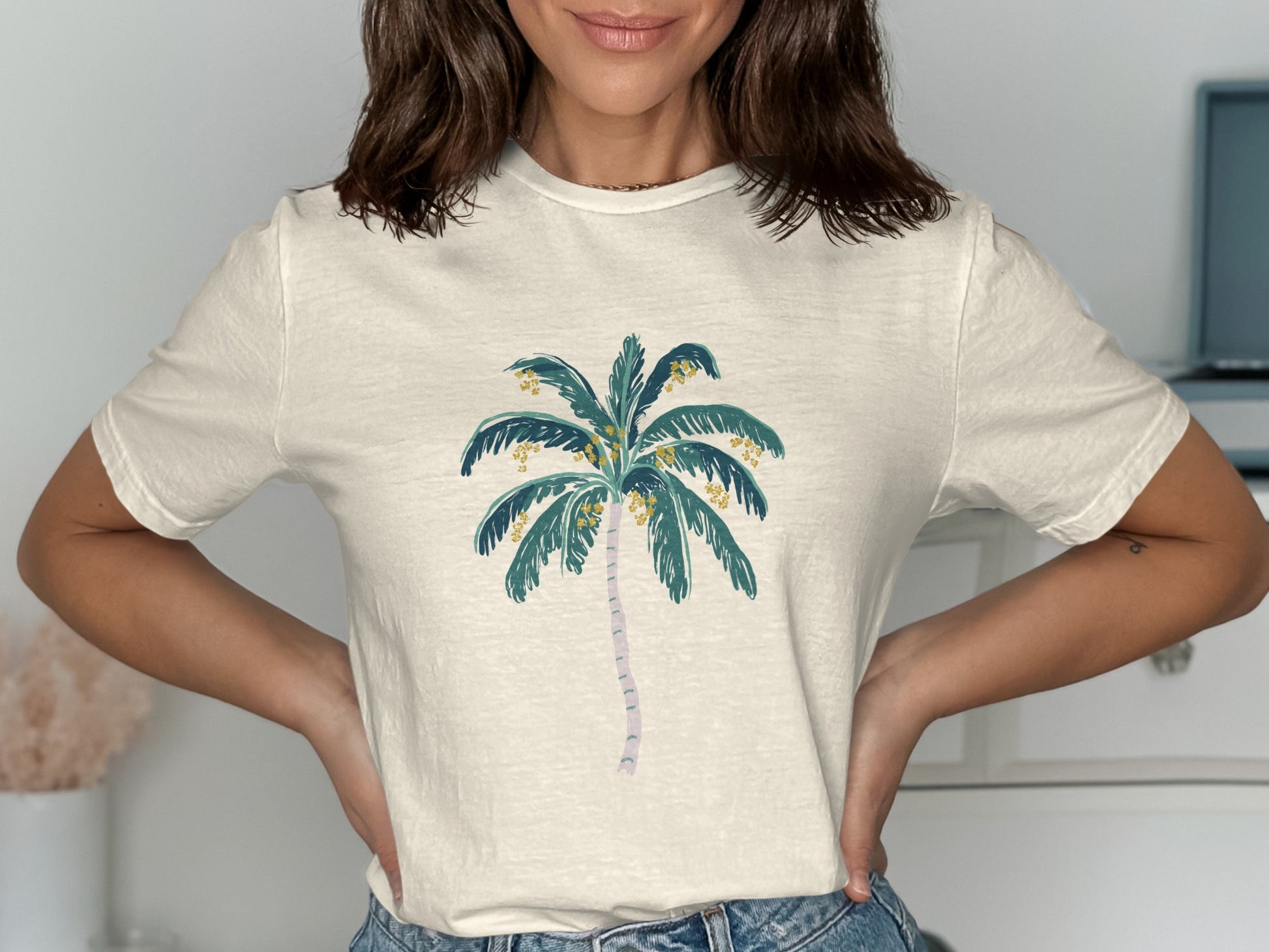 Cream t-shirt with a stylized palm tree graphic featuring yellow coconuts.