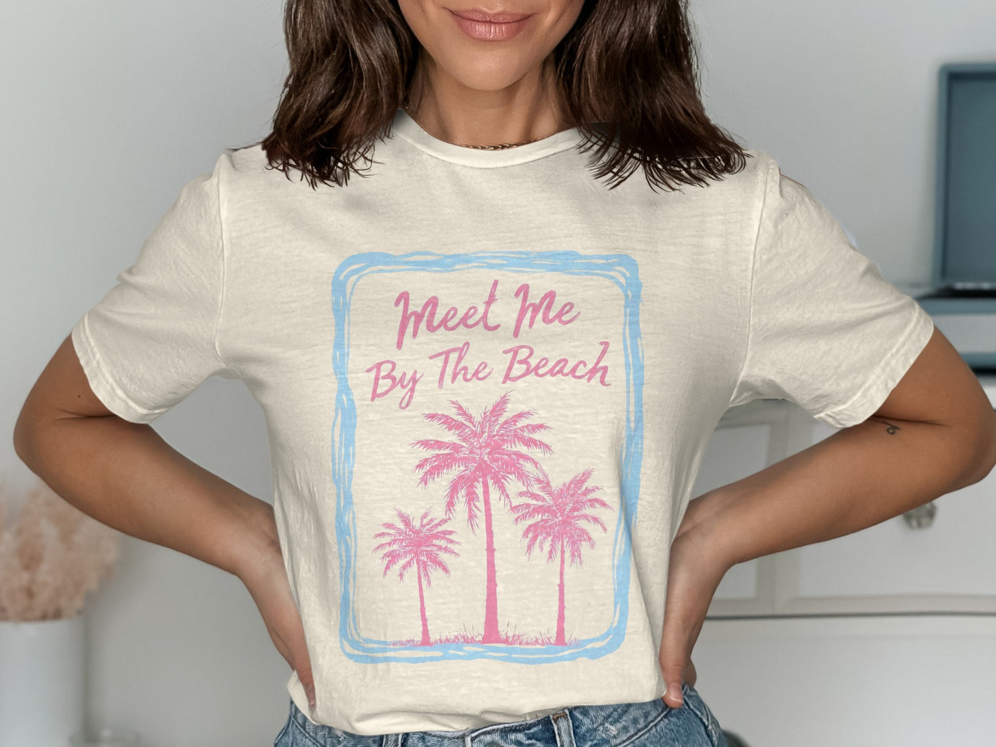 Cream t-shirt with pink palm trees and "Meet Me By The Beach" text.