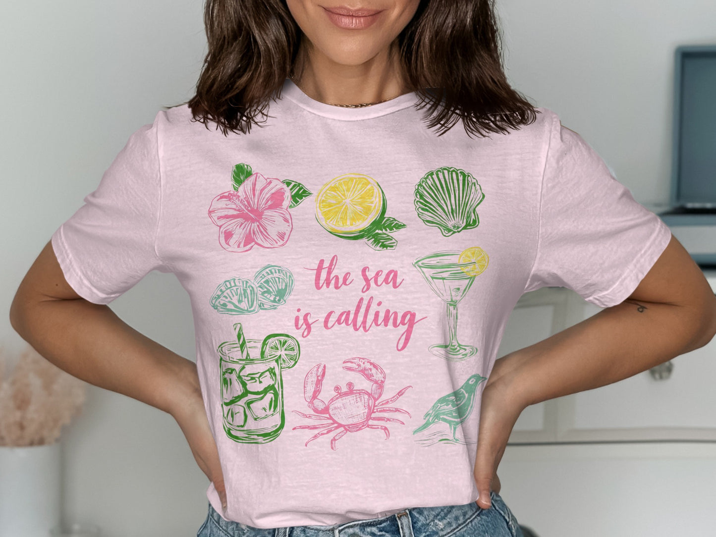 Pink t-shirt with colorful illustrations of sea life, fruit, and cocktails.