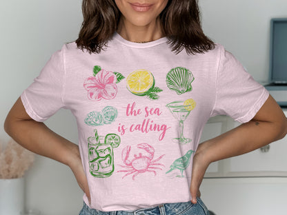 Pink t-shirt with colorful illustrations of sea life, fruit, and cocktails.