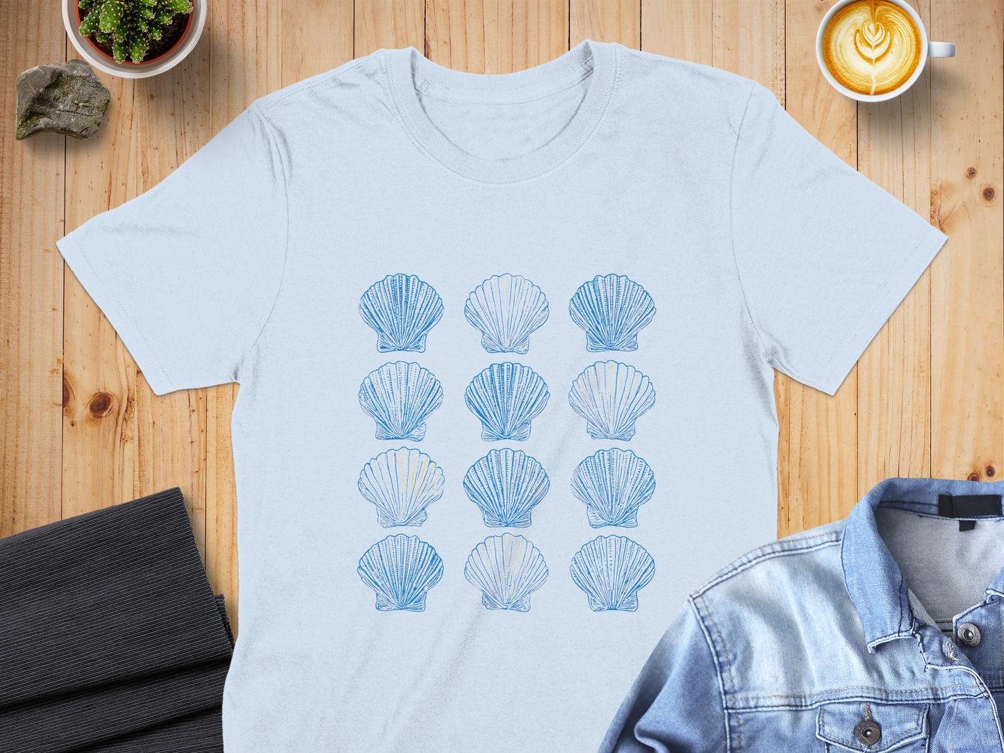 Light blue t-shirt with a repeating pattern of light blue seashells.
