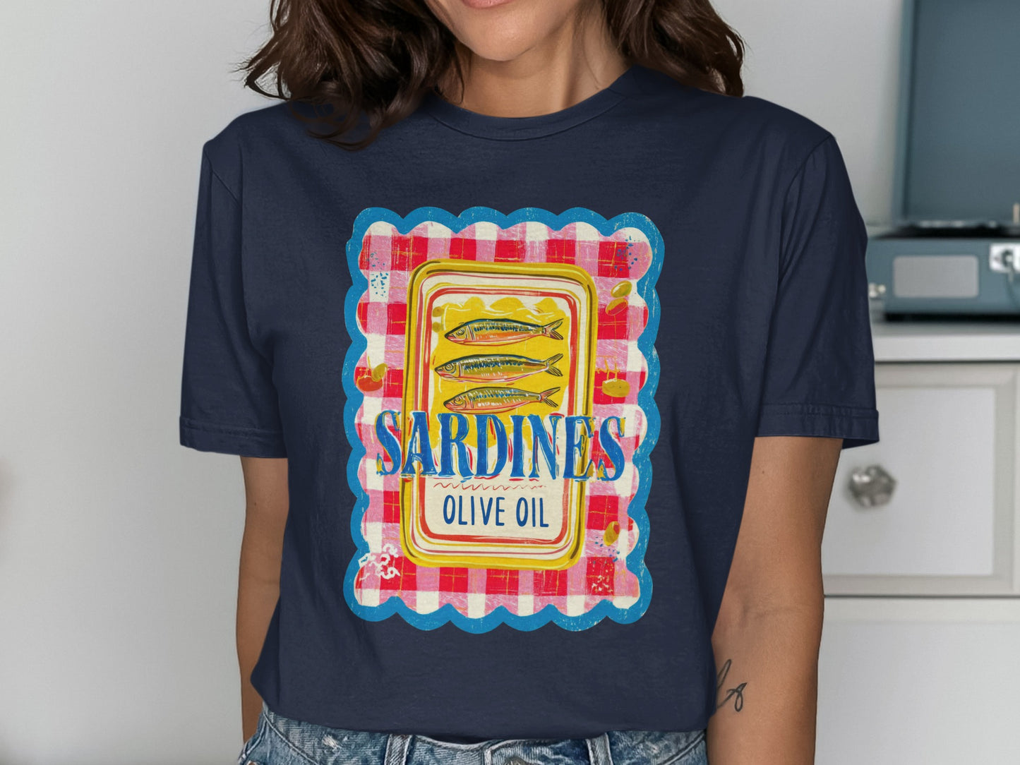 Dark blue t-shirt with a colorful label featuring sardines in olive oil.