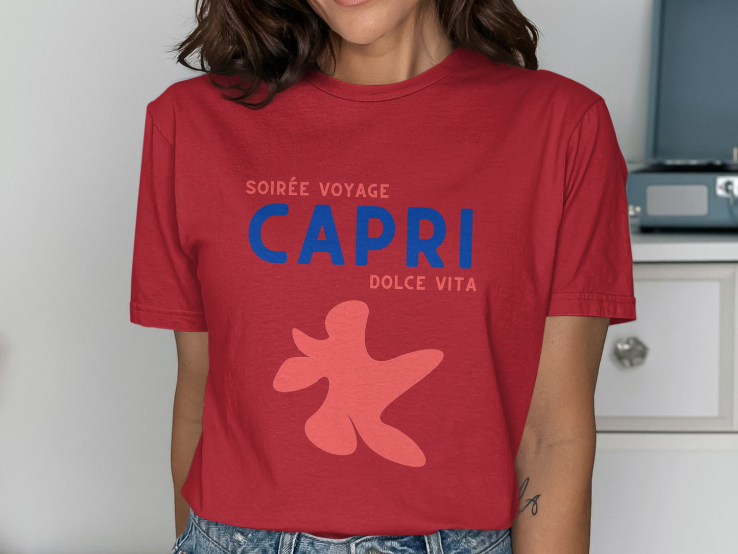 Red t-shirt with "Soirée Voyage Capri Dolce Vita" text and abstract coral design.