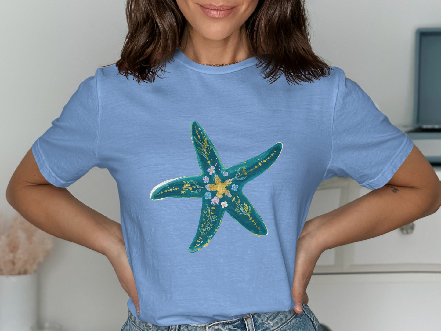 Light blue t-shirt with a turquoise starfish design adorned with small flowers.