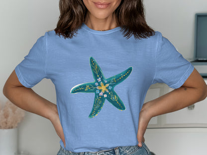Light blue t-shirt with a turquoise starfish design adorned with small flowers.